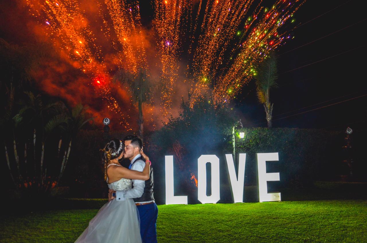 Fuegos artificiales y letras LOVE en el jardín